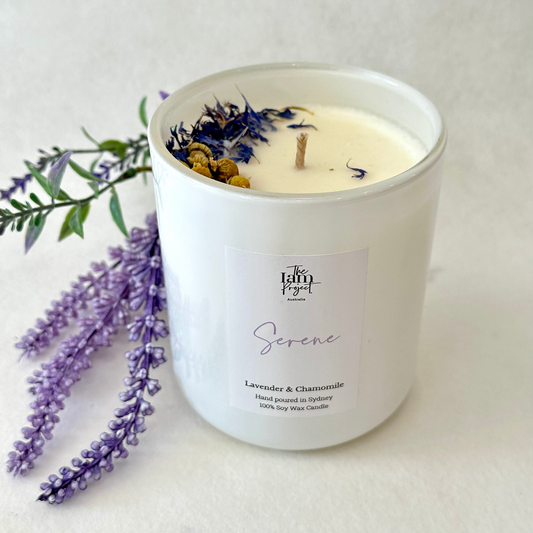 An exquisite Lavender & Chamomile botanical candle, radiating tranquility and calm. The candle features a beautiful blend of lavender and chamomile flowers, exuding a soothing aroma that creates a serene atmosphere. Perfect for moments of relaxation and rejuvenation.
