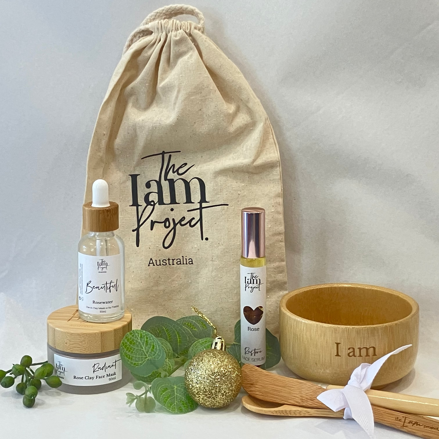 Collection of 'The I am Project Australia' products including bottles, a bowl, and a drawstring bag on a white background.