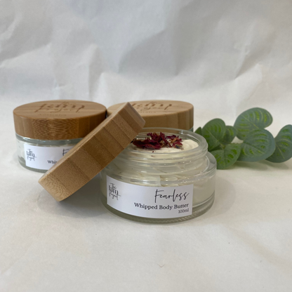 Two jars of 'Fearless' whipped body butter with wooden lids on a white background.