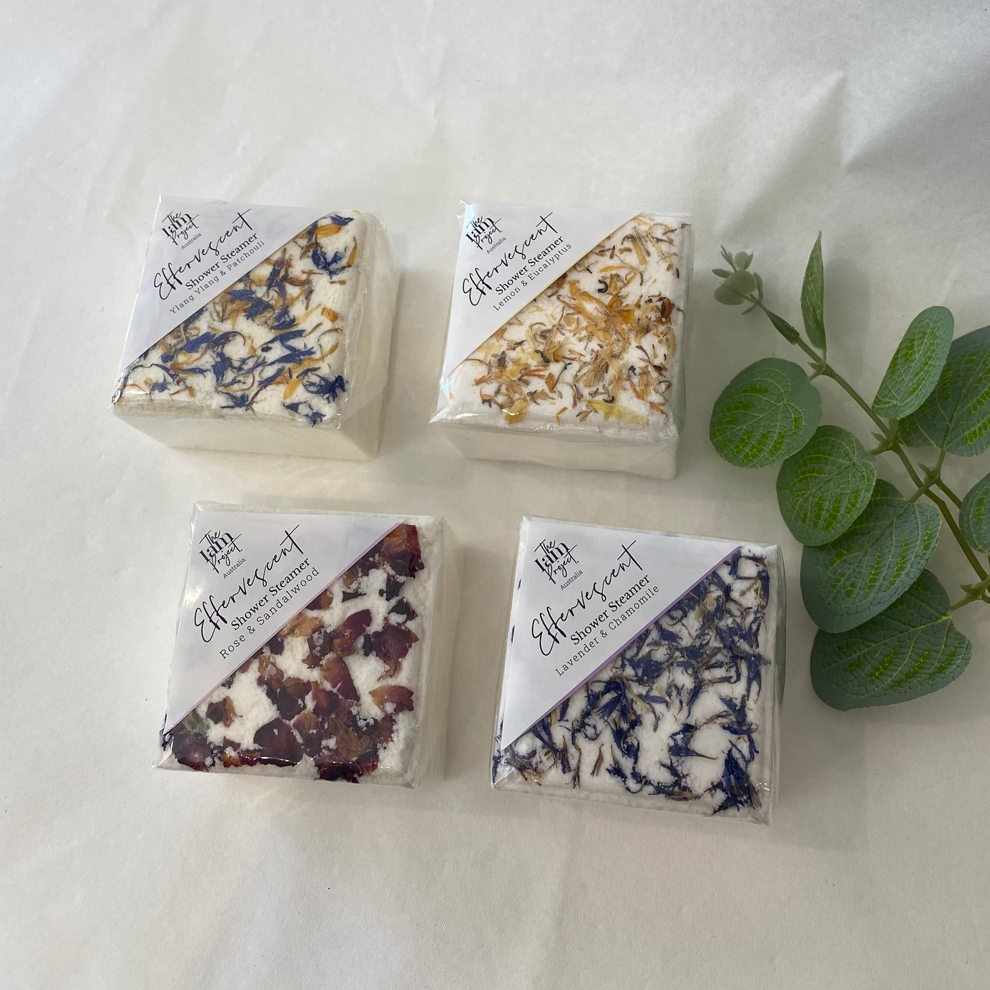 Four triangular shower Steamers with floral patterns on a white background