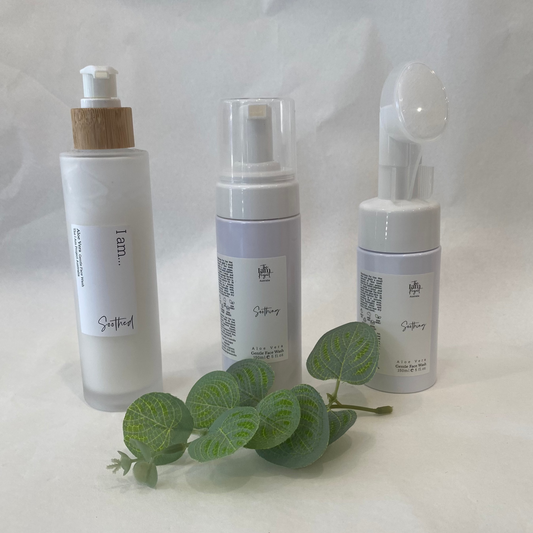 Three skincare bottles with a leaf on a white background