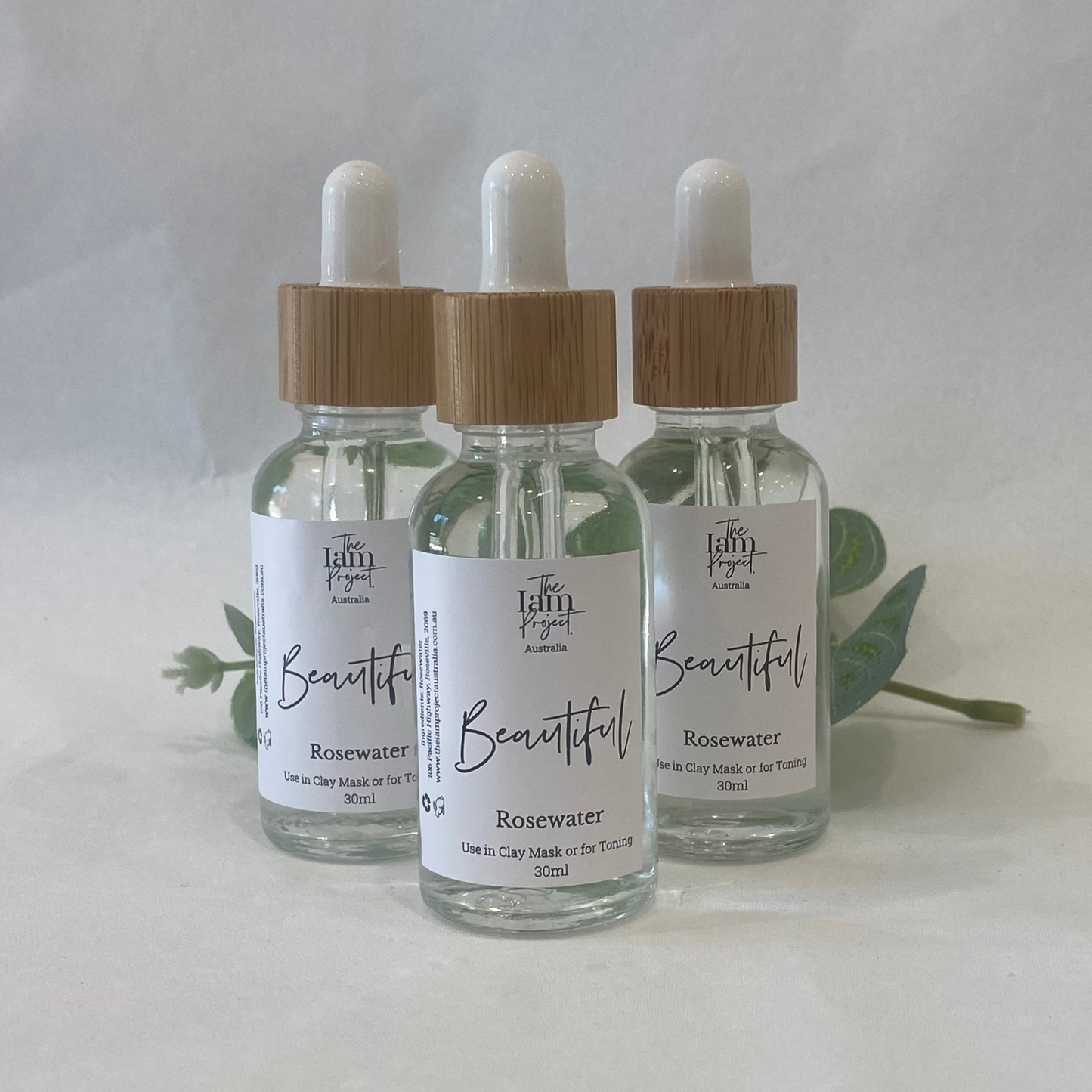 Three dropper bottles with wooden caps on a white background