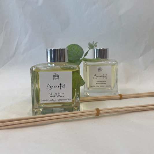 Two diffuser bottles with reeds on a white background