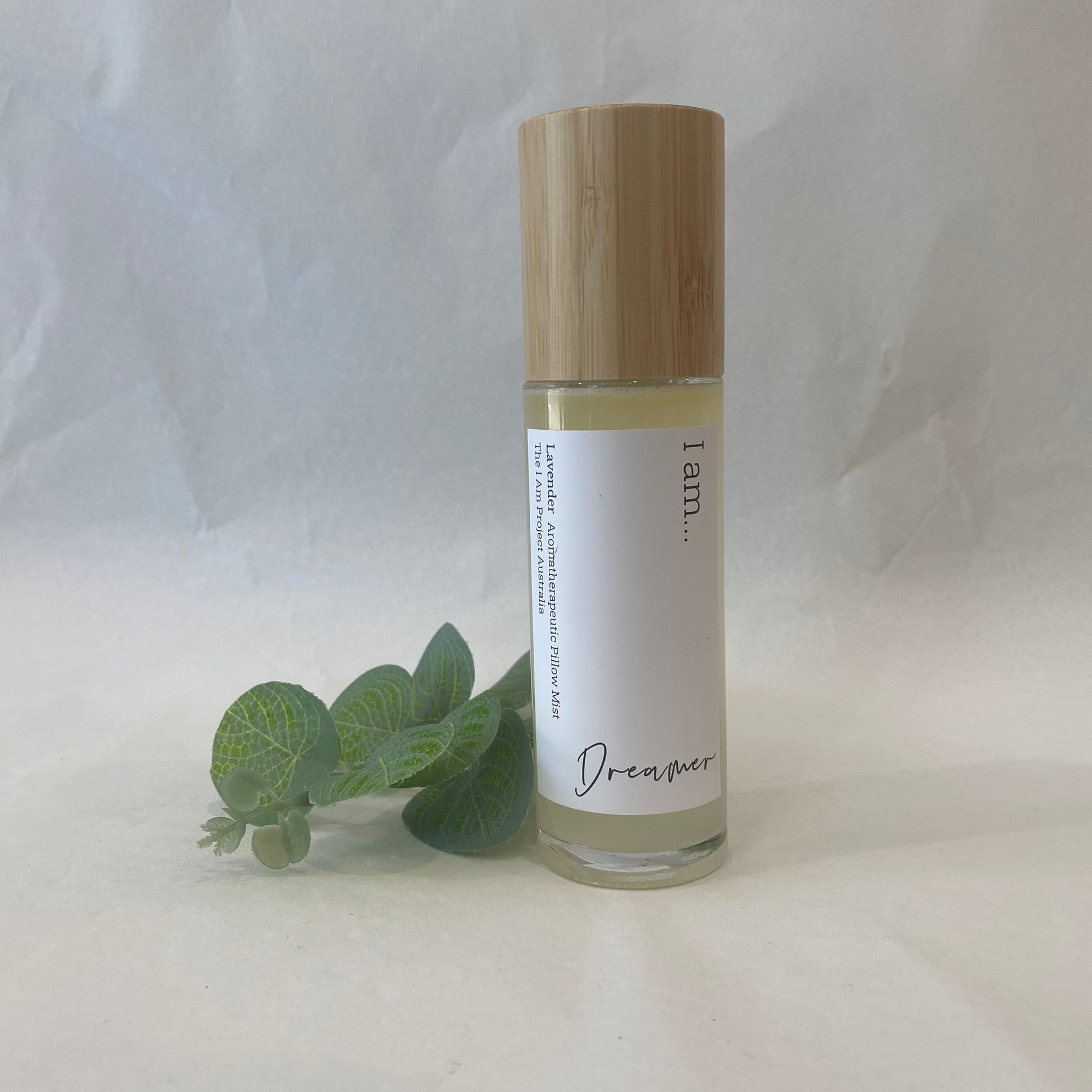 Skincare bottle with wooden cap and eucalyptus leaves on a white background