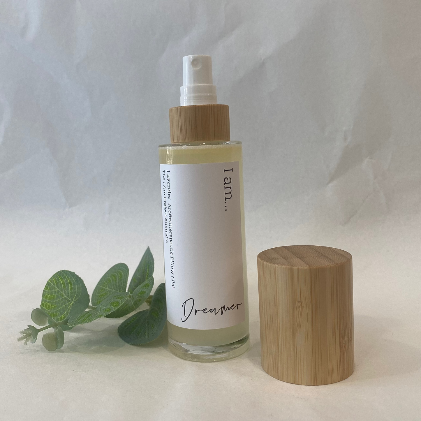 Skincare bottle with wooden cap and eucalyptus leaves on a white background
