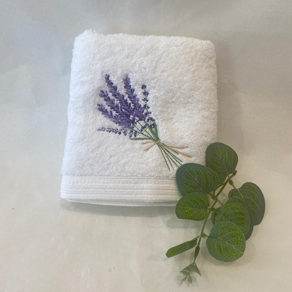 White towel with embroidered lavender design on a light background