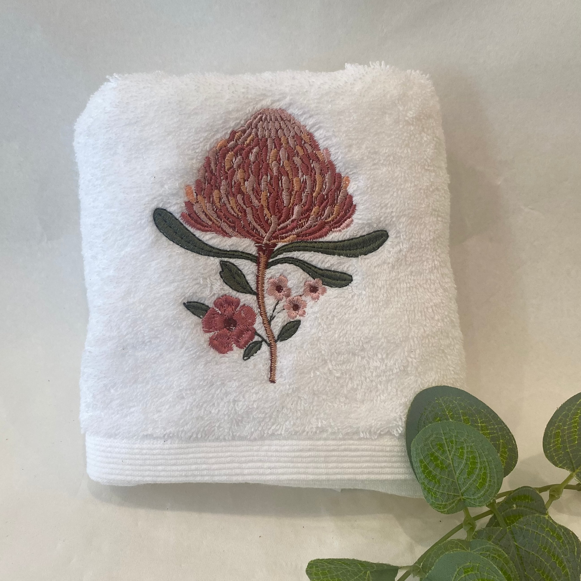 White towel with floral embroidery on a light background